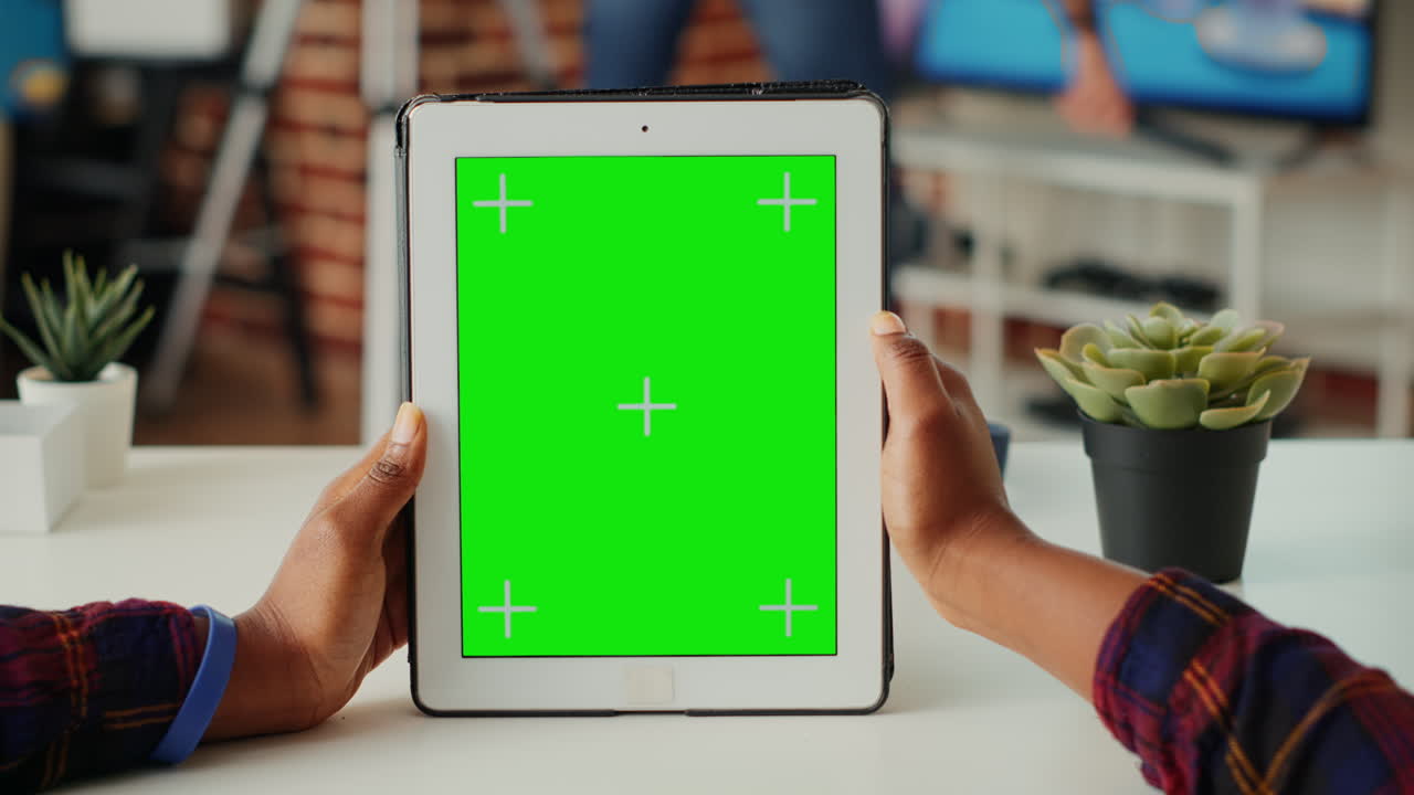 Office employee vertically holding wireless device with greenscreen display