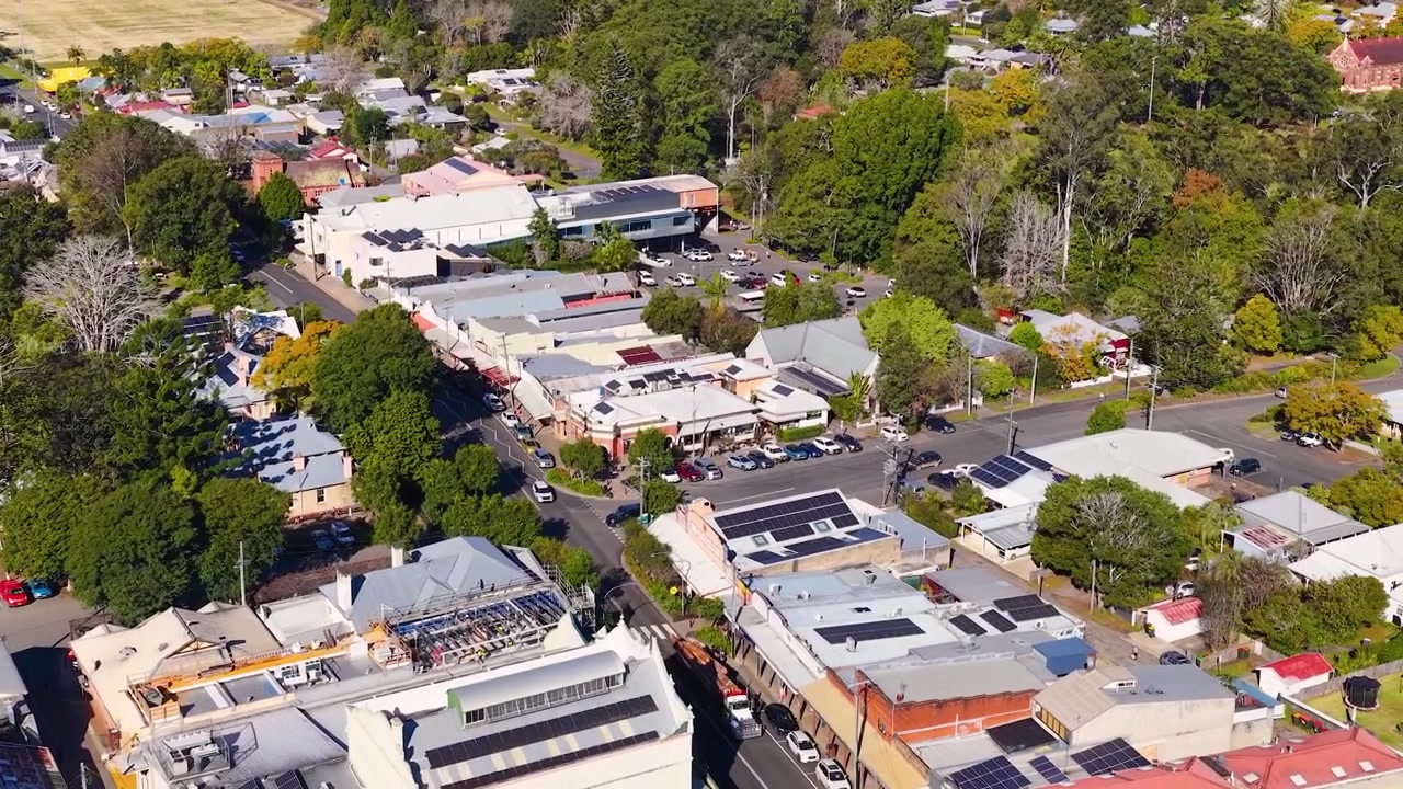 Una toma aérea de dron recorre un pueblo rural australiano a plena luz del día.