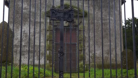 Abandoned-church-in-County-Cavan,-Ireland,-behind-iron-gate,-moss-covered,-historic,-eerie,-overcast