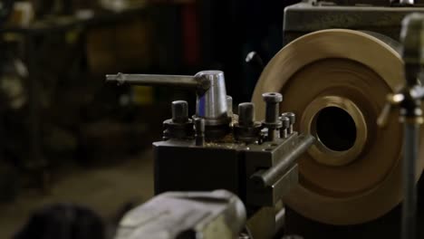 Metalsmith-working-on-machine-in-workshop-4k