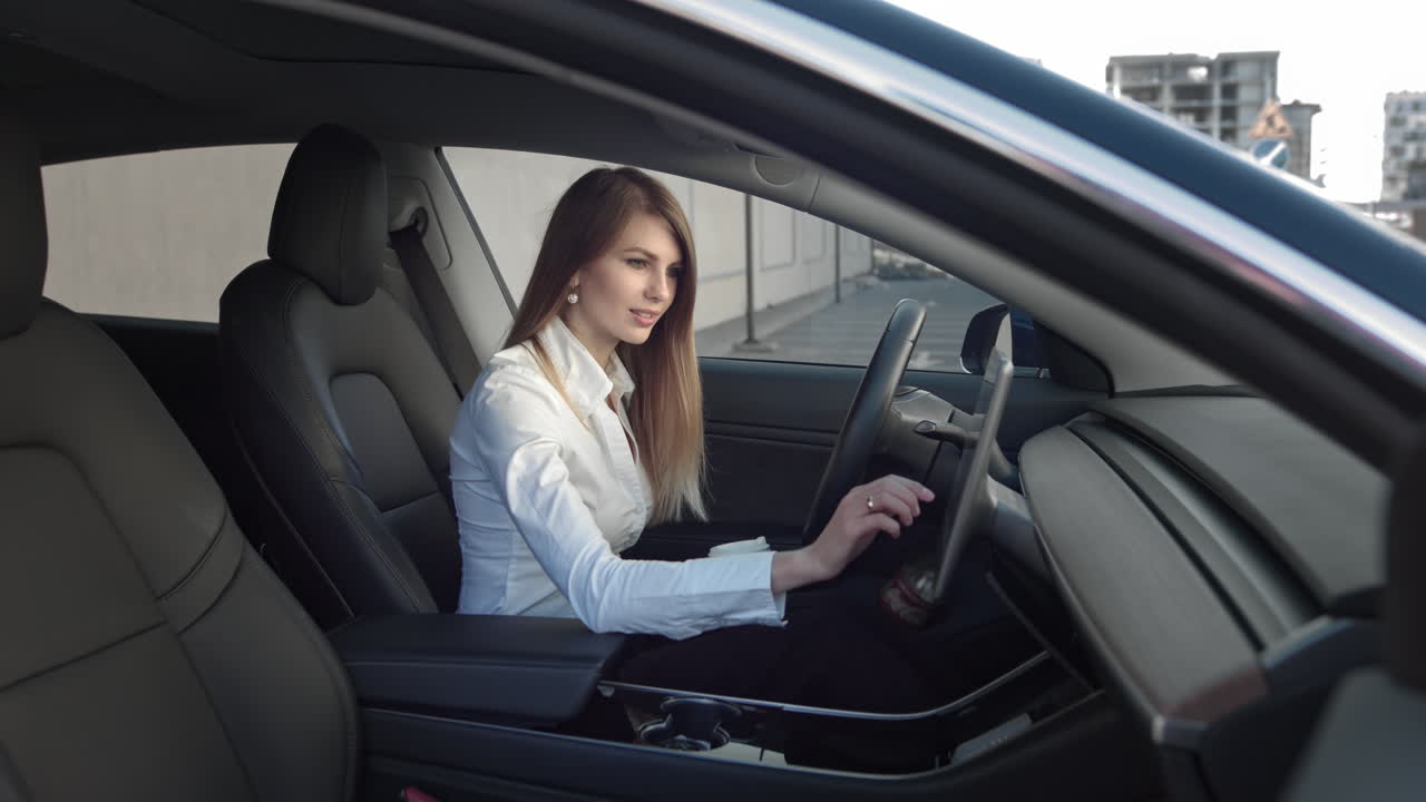 Ritratto di una giovane e splendida donna d'affari di successo seduta in una costosa auto sportiva elettrica
