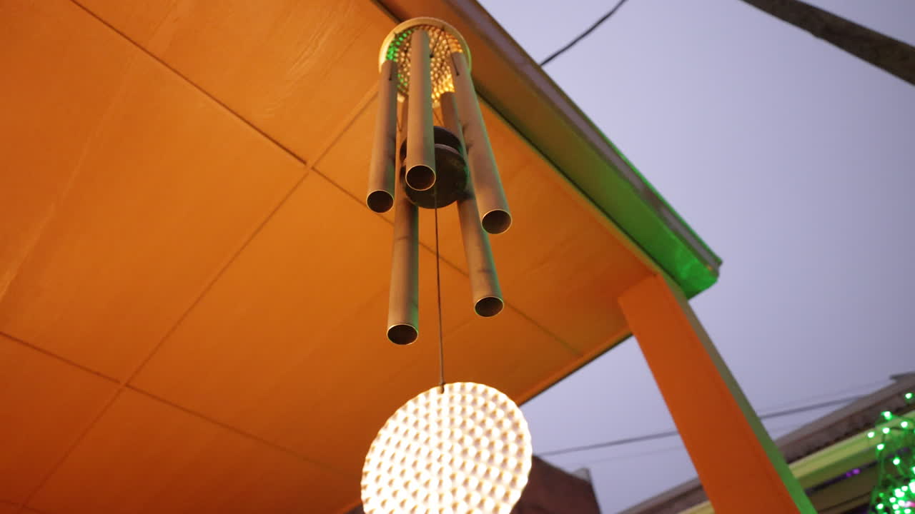 Wind chimes sway in the gently breeze, slow motion 4K