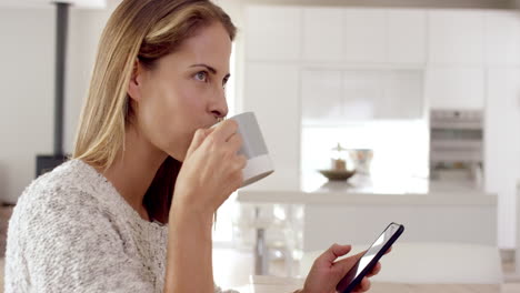 Mujer-Real-Usando-Teléfono-Móvil-En-Casa-Tomando-Café-Disfrutando-De-Un-Estilo-De-Vida-Relajante