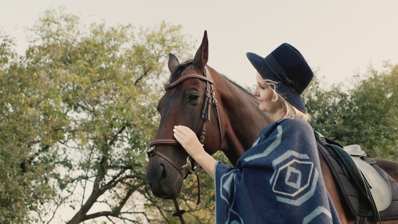 retrato de una mujer elegante con sombrero y poncho cerca de un caballo 1