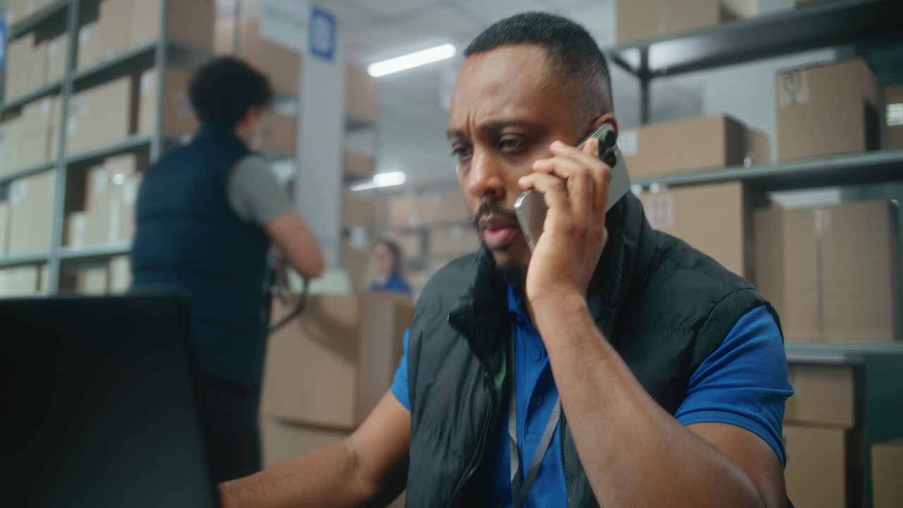 trabajador de almacén en teléfono y portátil