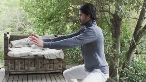 caucasian man practicing yoga on terrace in sunny nature, slow motion