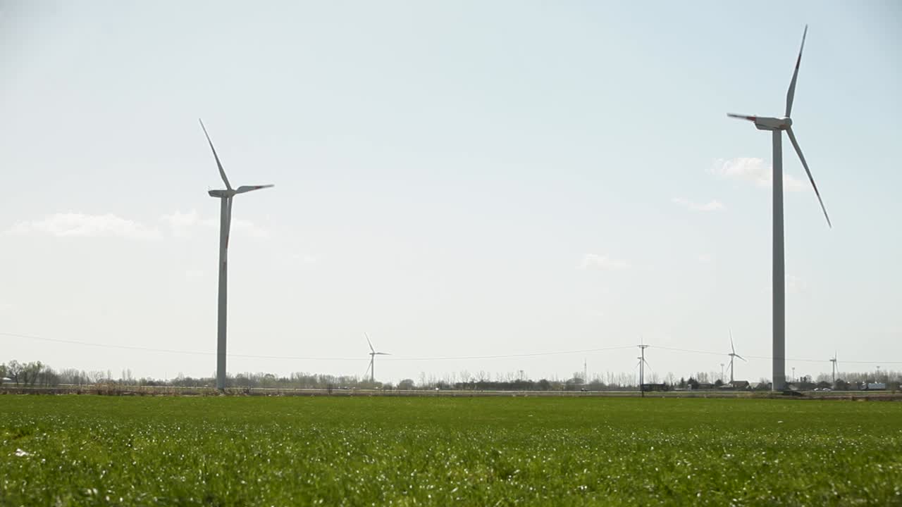 은 하늘을 가진 초록색 에서 이 나는 날에 회전하는 풍력 터빈