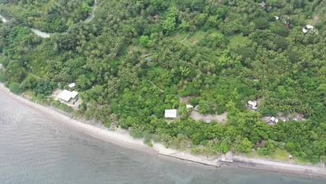 Aerial-top-down-view-over-a-greenery-coastline-with-a-beautiful-beach-with-turquoise-water-and-a-coral-reef,-establishing-shot,-conservation-concept