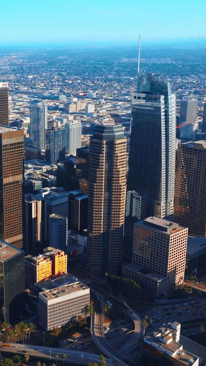 Gorgeous skyscrapers surrounded by busy traffic roads in Los Angeles, USA. Beautiful high buildings at the backdrop of endless cityscape. Vertical video