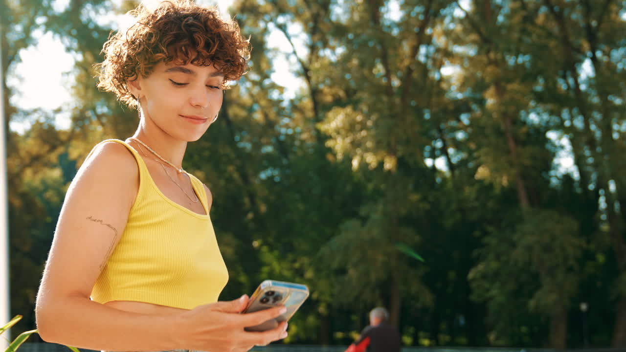 una mujer joven tomando una selfie en un parque.