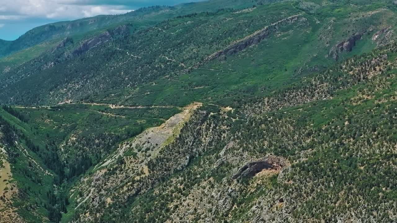 Montañas y colinas verdes en Colorado con cielo despejado y carretera