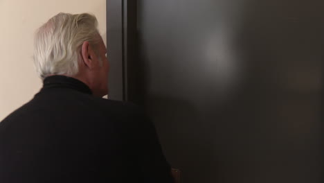 elderly man checking a door