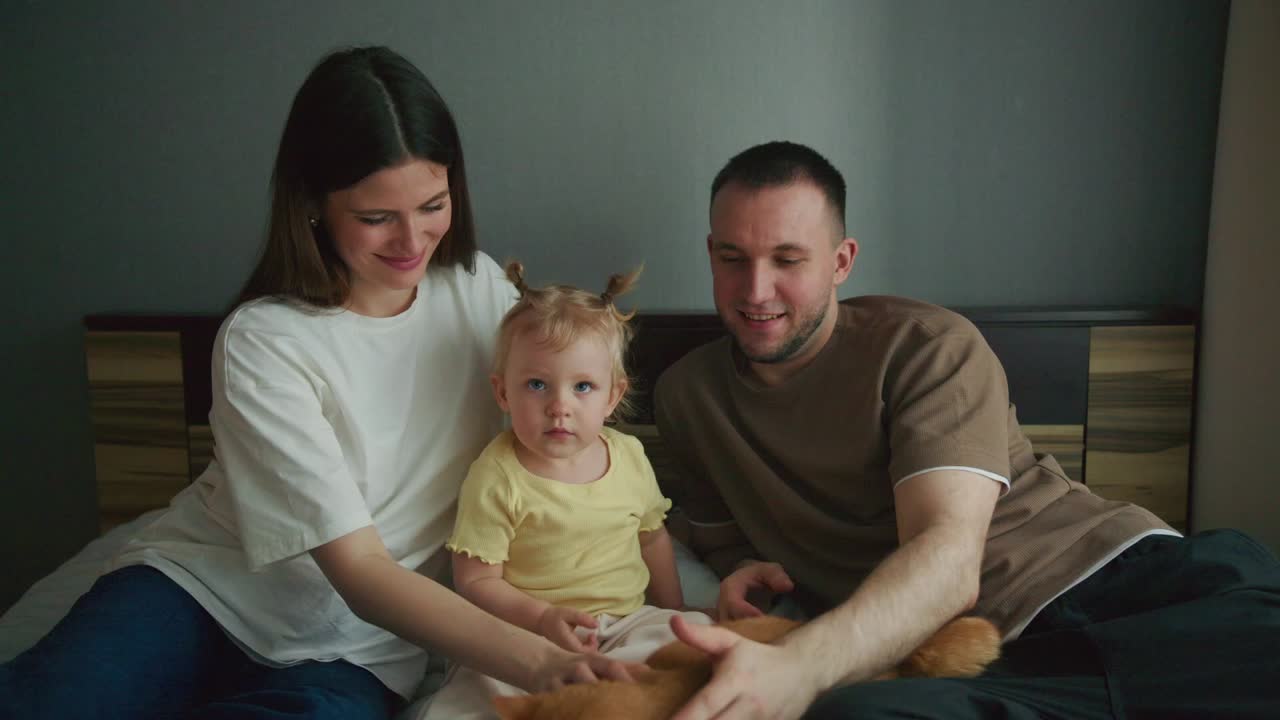 Семья с малышом и котом отдыхает вместе на кровати