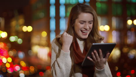 happy lady receiving message tablet outside. excited girl looking tablet screen