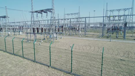 estación transformadora, seguridad energética de los países. una central eléctrica rodeada de alambre de púas y supervisada por cámaras industriales.