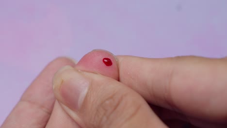 poking their finger to obtain a blood sample