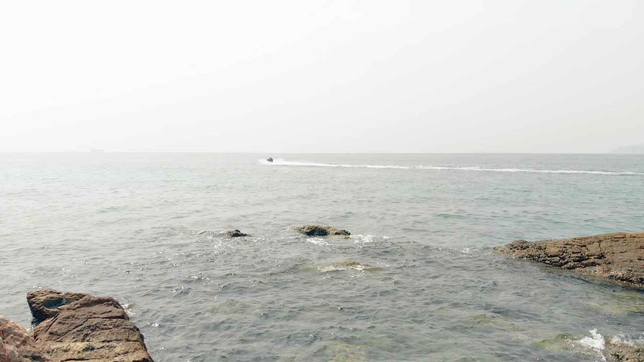 camera shoots fast water scooter with tourists and clear sea