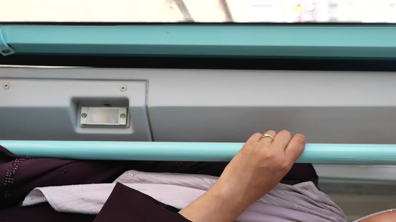 Hand holding onto train rail