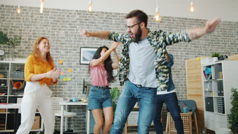 happy friends dancing in an office
