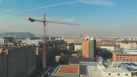 aerial shot as a crane working on a construction, bird eye view over a city in europe