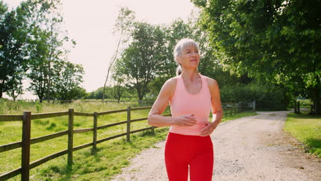 mujer mayor sana disfrutando de correr por el campo