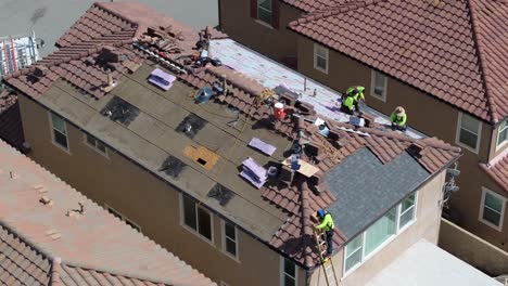 construction workers prepare house rooftop for solar panel installation in residential neighborhood