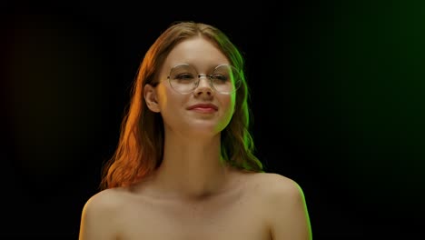 portrait of a young woman with glasses under colored lights