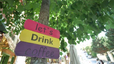 colorido cartel de la cafetería en el árbol