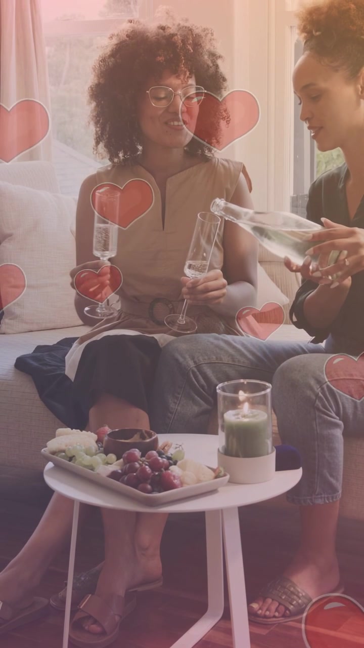 Video verticale: Donne, donna a destra che prende una bottiglia, la inclina, versa e condivide, con sovrapposizione a cuore e tema lifestyle.