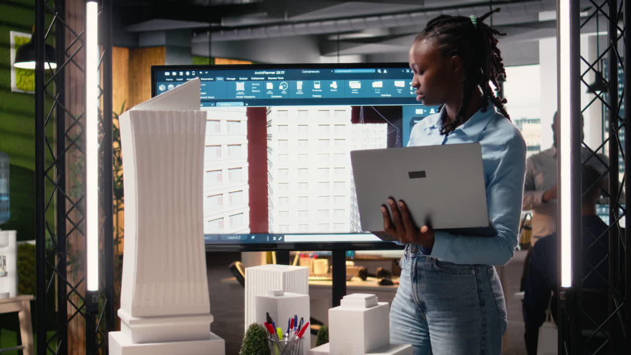 African american female evaluating 3D building model for measurements