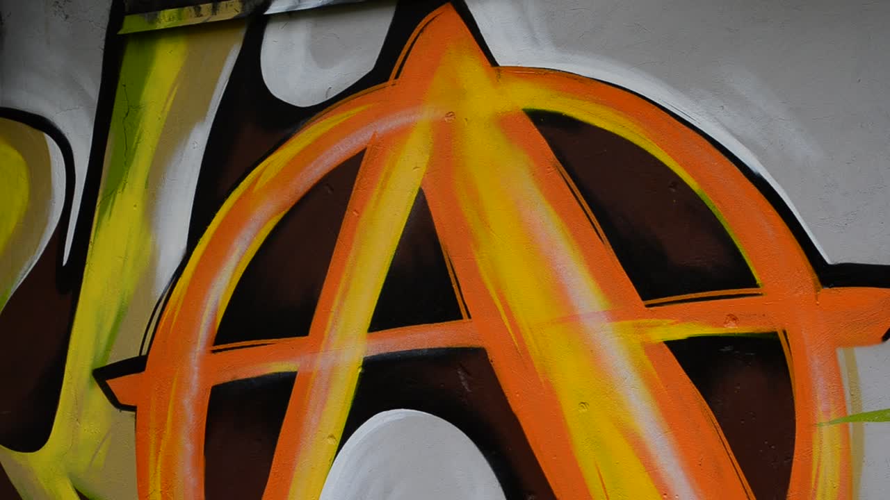 The artist draws graffiti on a fence, abstraction