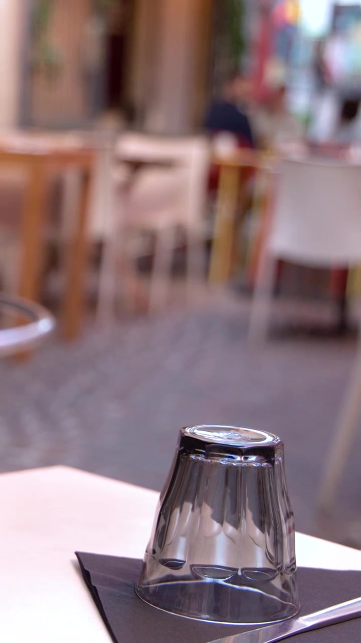 Primo piano di un bicchiere su un tovagliolo in un ristorante all'aperto con sfondo sfocato