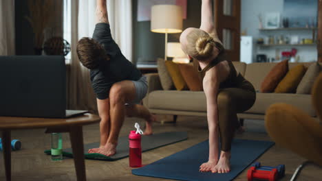 couple stretching body home on sport mat. pair practicing yoga position together