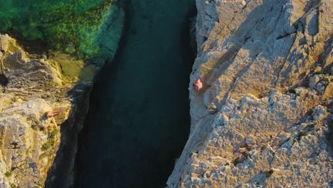 una imagen extraordinaria de un buzo de acantilado preparándose para sumergirse en el reluciente lago azul profundo, saboreando la experiencia de las aguas cristalinas