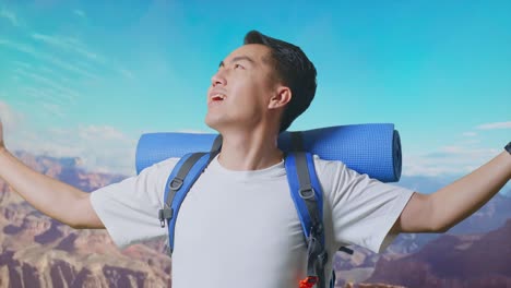 close up of asian male hiker with mountaineering backpack smiling and spreading arms enjoy looking the view around while traveling at the top of mountain