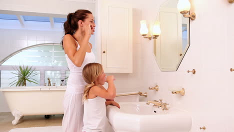 Mother-and-daughter-brushing-their-teeth