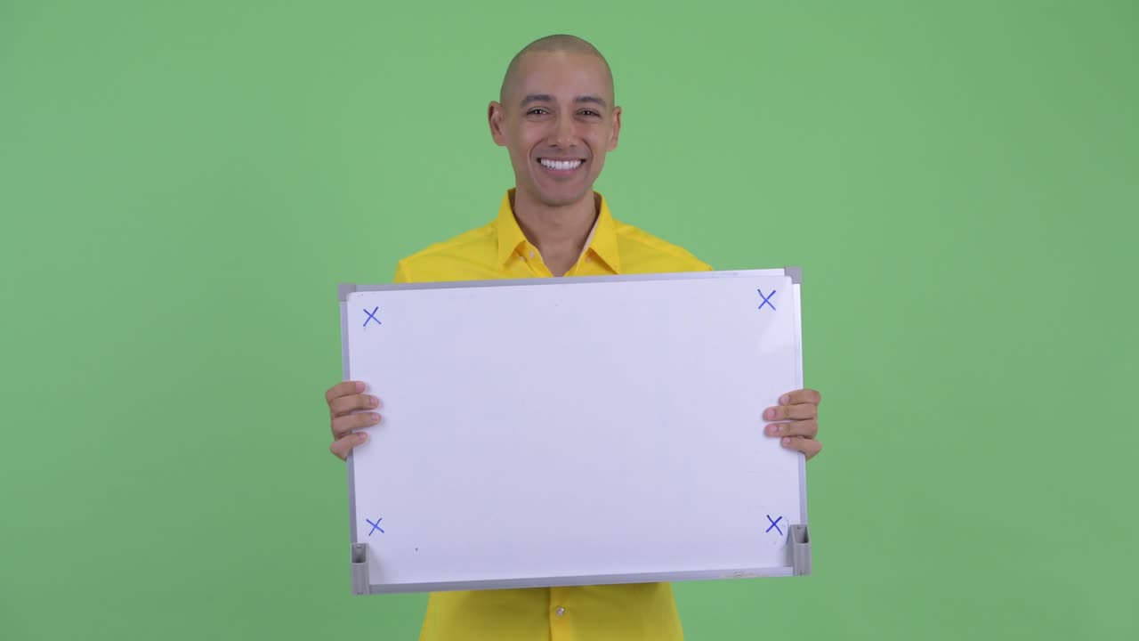 Happy handsome bald businessman with white board