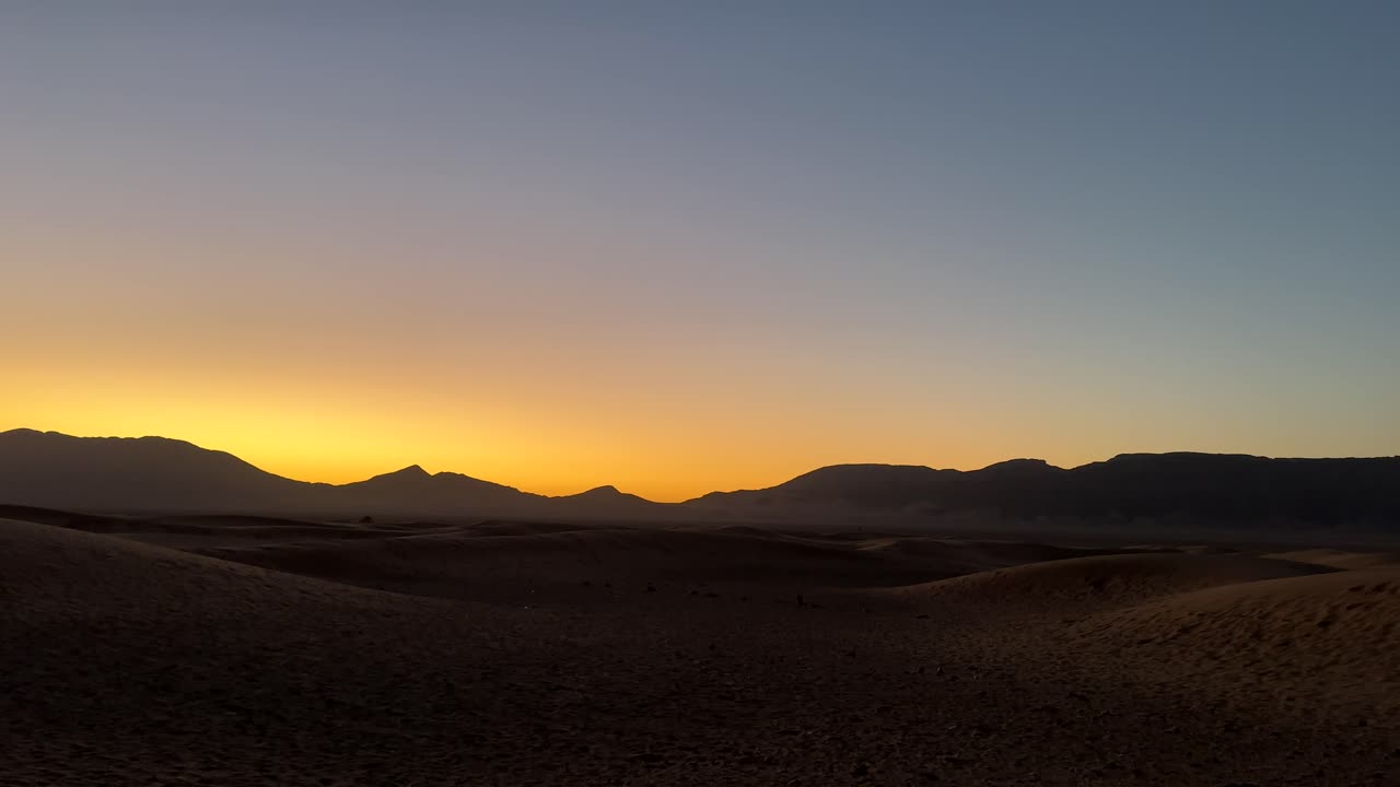 hermoso paisaje desértico con puesta de sol naranja detrás de las montañas