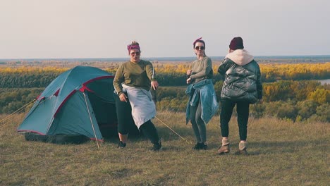 tipsy girls at blue tent have outdoor party against river slow