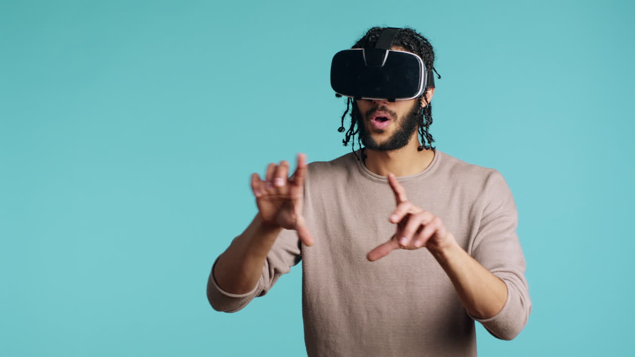 Man wearing virtual reality headset, doing swiping gestures, studio background