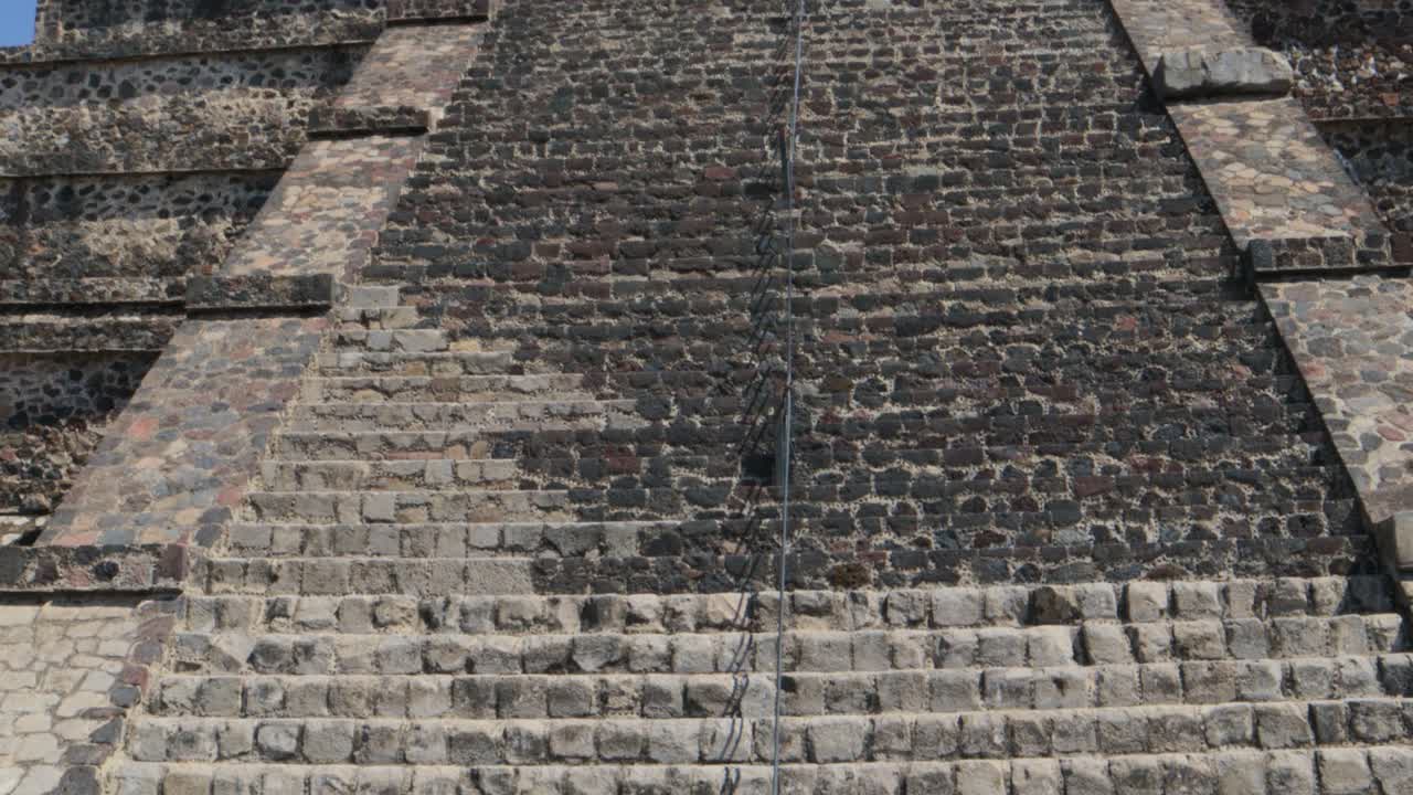 una toma cerrada de una mujer por detrás tomando una foto con su smartphone de la pirámide de la luna en la zona arqueológica de teotihuacan en méxico
