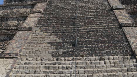 a closed shot of a woman from behind taking a photo with her smartphone of the pyramid of the moon in the archaeological zone of teotihuacan in mexico