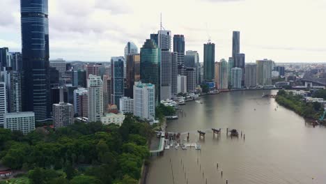 Vista-Aérea-Drone-Sobrevolando-El-Río-Brisbane-Capturando-El-Paisaje-Urbano-Del-Centro-De-La-Ribera,-Edificios-De-Gran-Altura-Y-Rascacielos-En-El-Distrito-Central-De-Negocios,-Ciudad-Capital-De-Queensland,-Australia