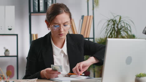 mujer de negocios rica feliz trabajando en una computadora portátil contando dinero en efectivo, calcular ganancias ingresos ganancias