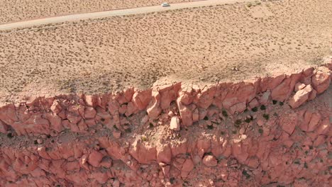 Aerial-cinematic-view-of-a-canyon-and-dirt-road-in-Atacama-Desert-at-sunset