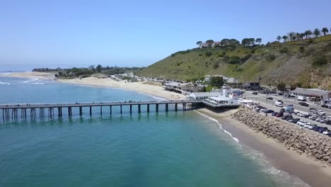 malibu pier with white restaurant, highway and parking lot