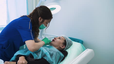 female doctor does lip augmentation injection to lady