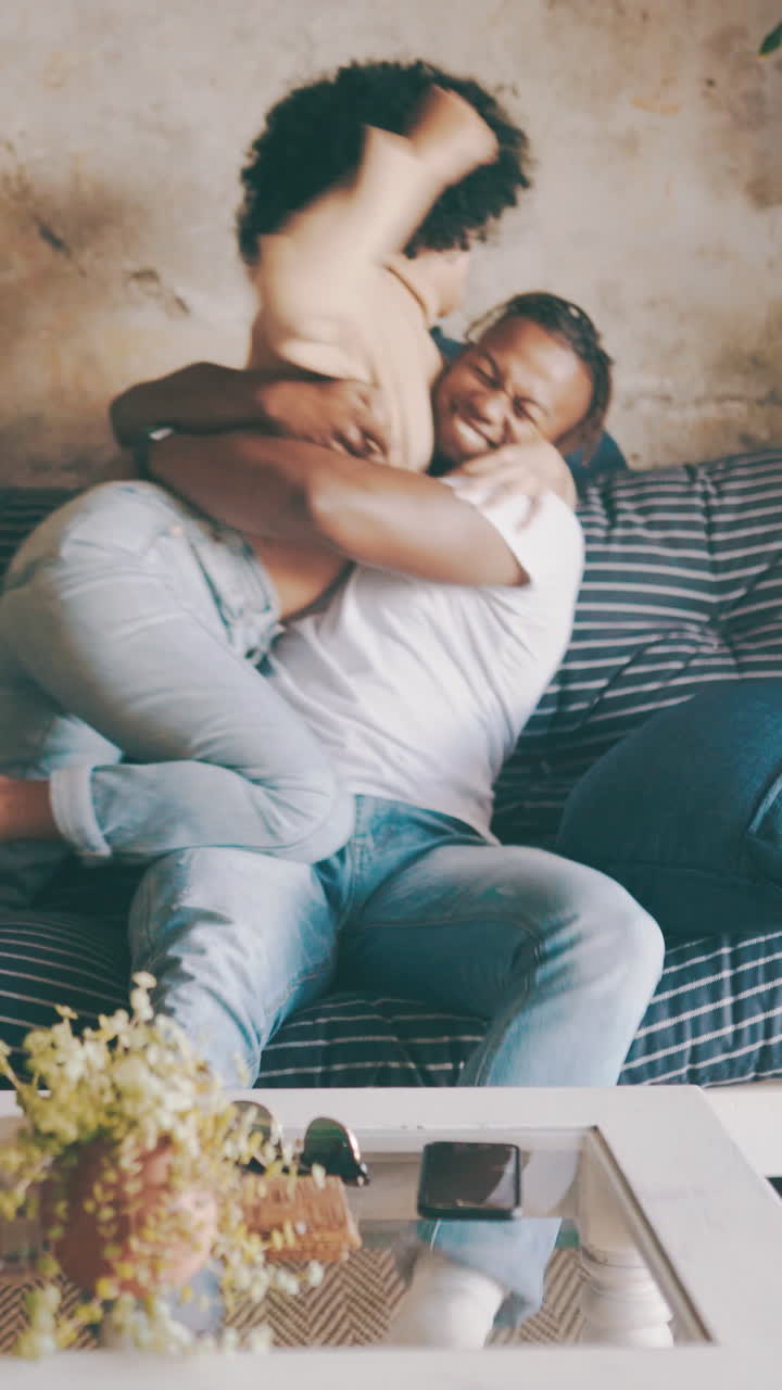 Happy Couple Having a Playful Pillow Fight and Hugging