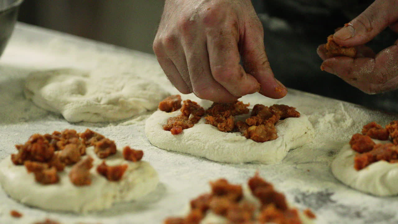 mano de un panadero poniendo streusel encima de la masa