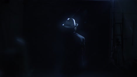 man in white hat - back view in dark studio